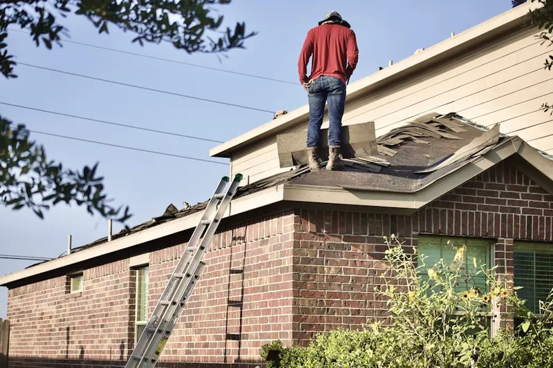 Professional roofer working on a residential roof in Cady